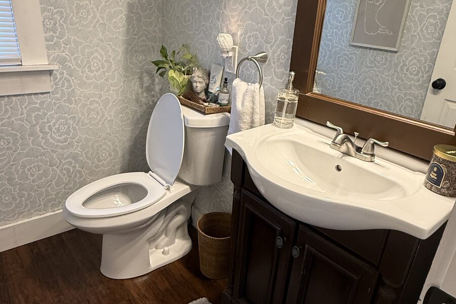 Clean bathroom with a dark-wood vanity, white sink, and framed mirror